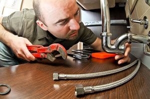 a man works with a wrench | burlington plumber